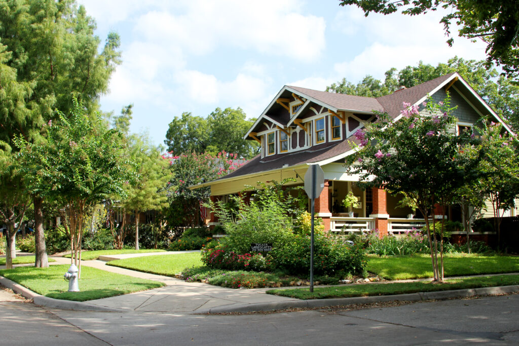 Craftsman bungalow with deep eaves and crepe myrtles in the Fairmount Historic District, Fort Worth, Texas