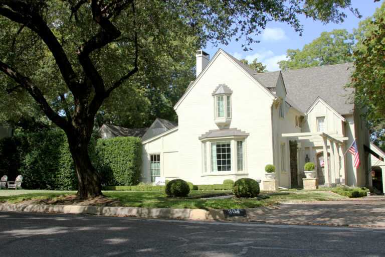 Two-story home with mature oak trees on a residential street in the Monticello area of Fort Worth, Texas