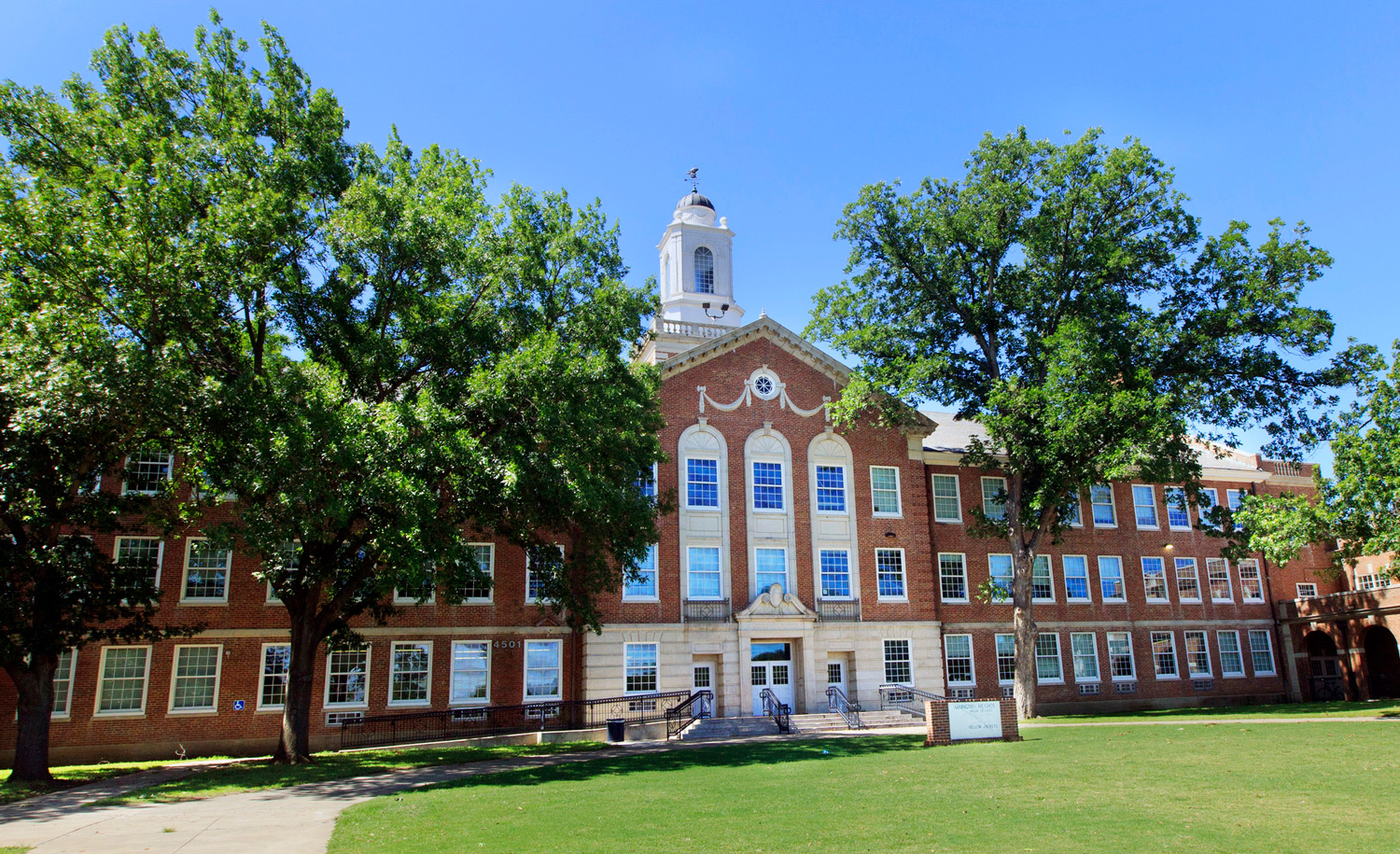 Arlington Heights High School tower rising above mature trees in the Arlington Heights neighborhood of Fort Worth, Texas